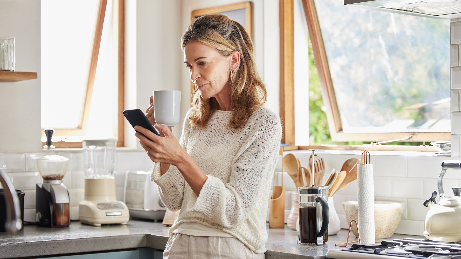 Woman looking at phone in kitchen