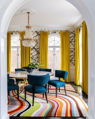 elegant dining room with patterned rug and drapes and wallpaper