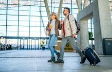 A couple looks worried while walking through an airport.