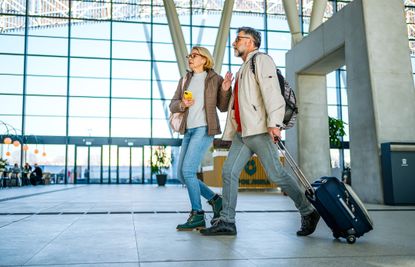 A couple looks worried while walking through an airport.