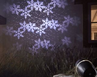 snowflakes projector on a side of a house - cox and cox