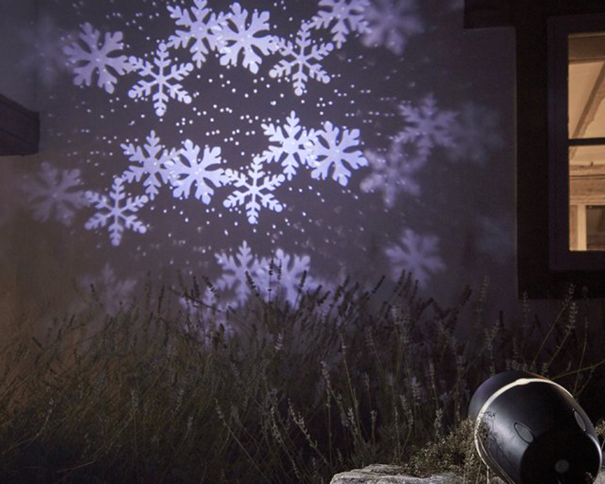 snowflakes projector on a side of a house - cox and cox