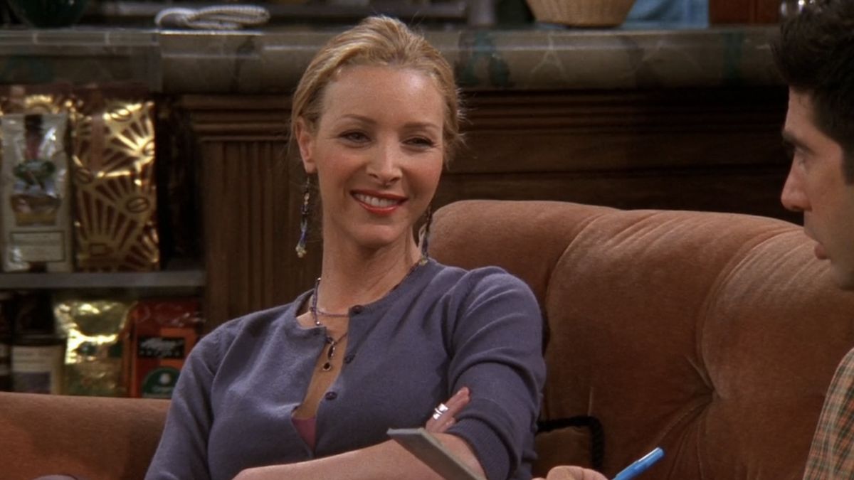 Phoebe smiling on the couch in Friends