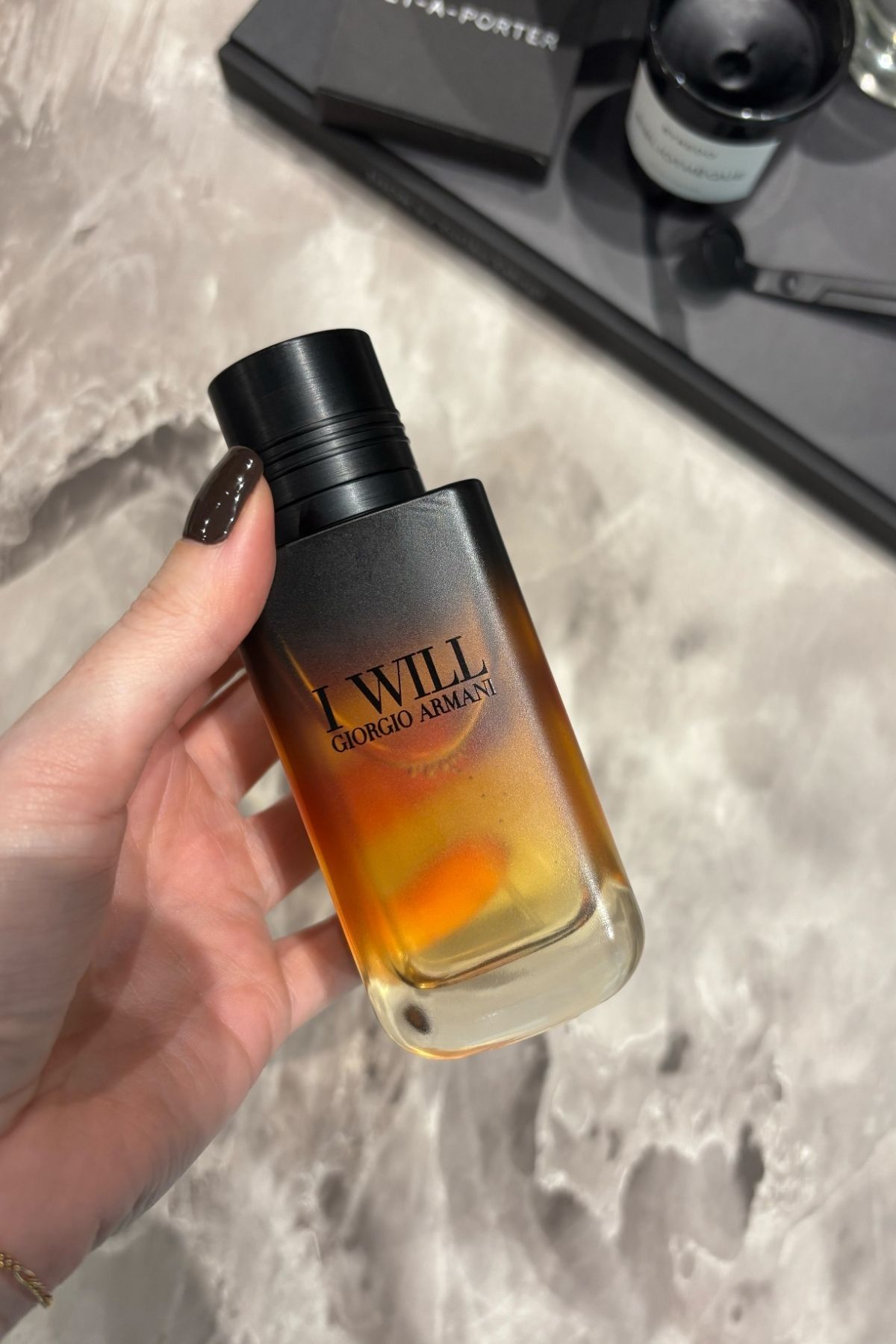 Deputy beauty editor Grace Lindsay holding a bottle of Giorgio Armani I Will