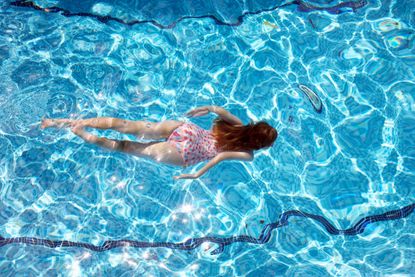 a woman swimming in a lane in an swimming pool