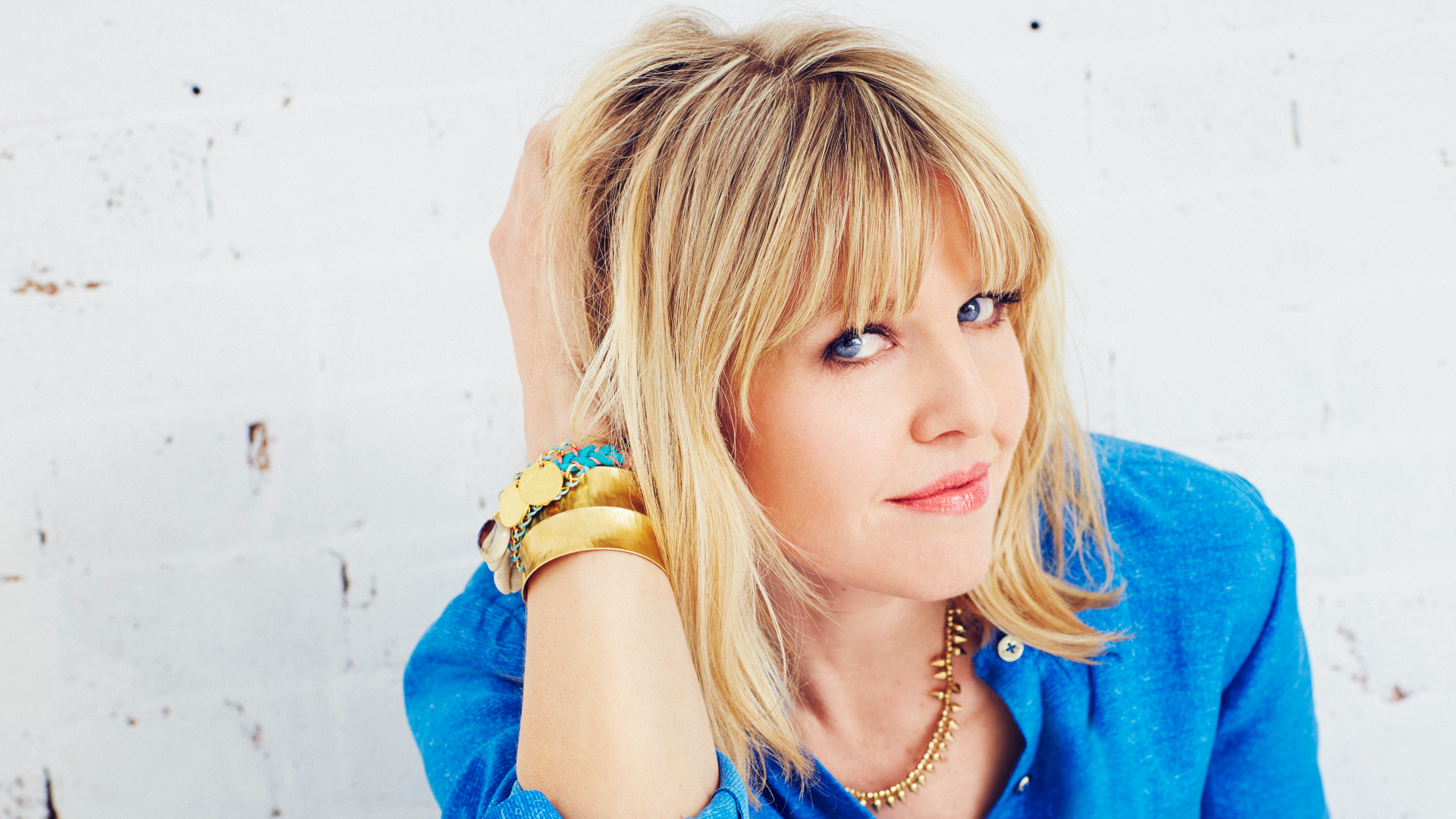 A headshot of Ashley Jensen wearing a blue blouse