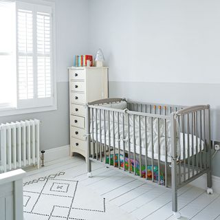 Grey nursery with two tone walls, cot bed and geometric rug