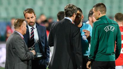 England head coach Gareth Southgate speaks with match officials during a break in play