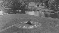 Man standing next to a giant sundial