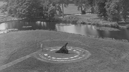 Man standing next to a giant sundial