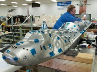 The Dream Chaser model with its Atlas V launch vehicle is undergoing final preparations at the Aerospace Composite Model Development Section's workshop for buffet tests at the Transonic Dynamics Tunnel at NASA Langley. Image released May 7, 2012.