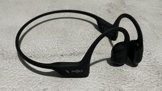 Shokz OpenRun Pro bone conduction sports headphones on a concrete surface