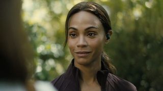Zoe Saldana in purple sports gear and earbud in her left ear, starring in Lioness season 3 episode 1 (2026). 