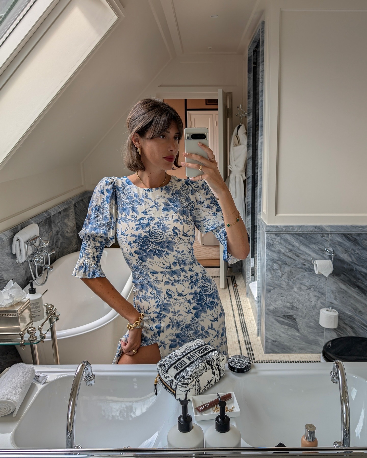 @juliesfi taking a selfie wearing a floral dress and a half-up, half-down hairstyle