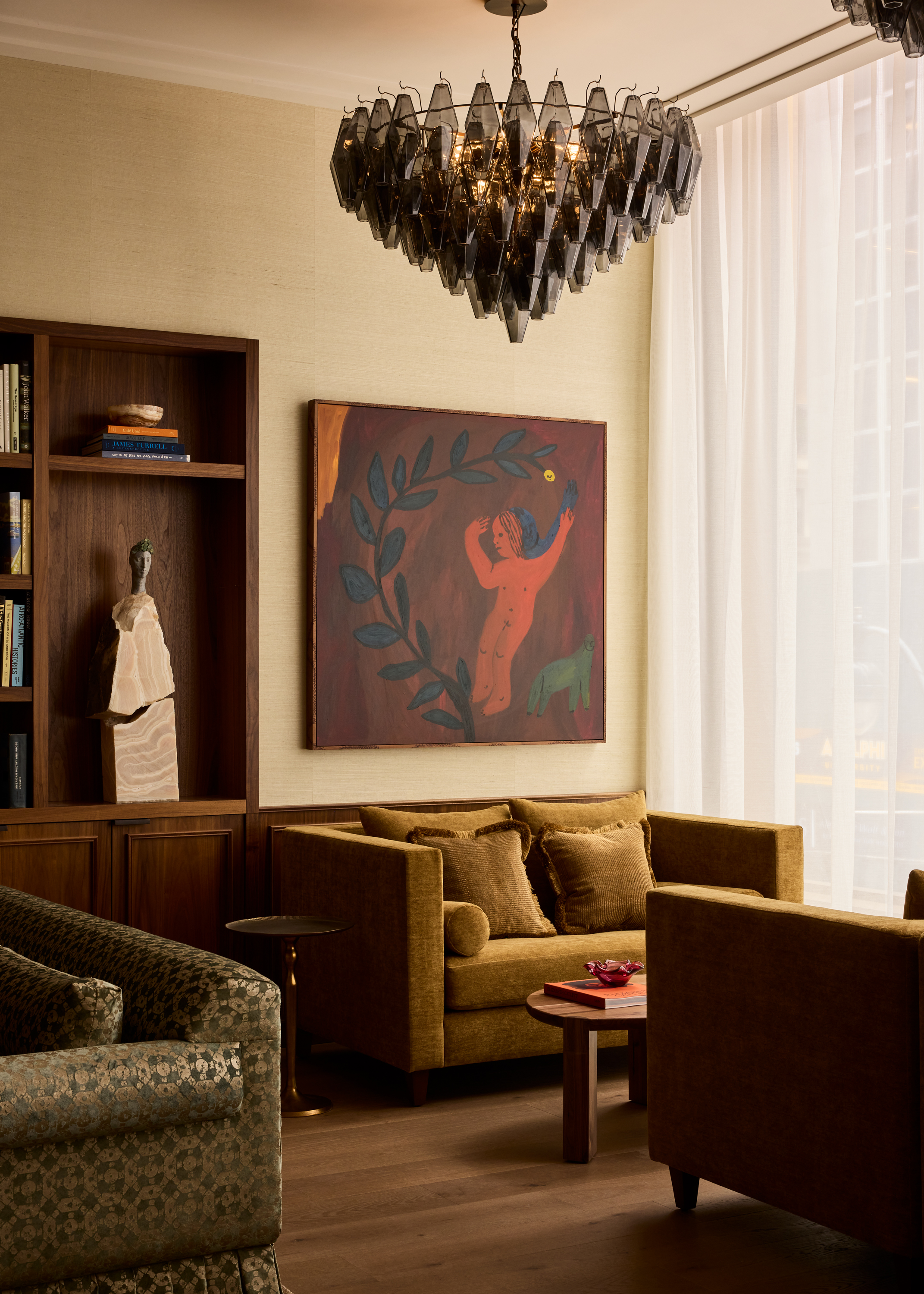 A green couch sits next to a window as Moss, a new members club in NYC.