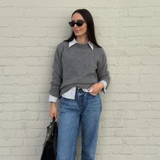 Olivia Perez wearing a gray sweater and jeans