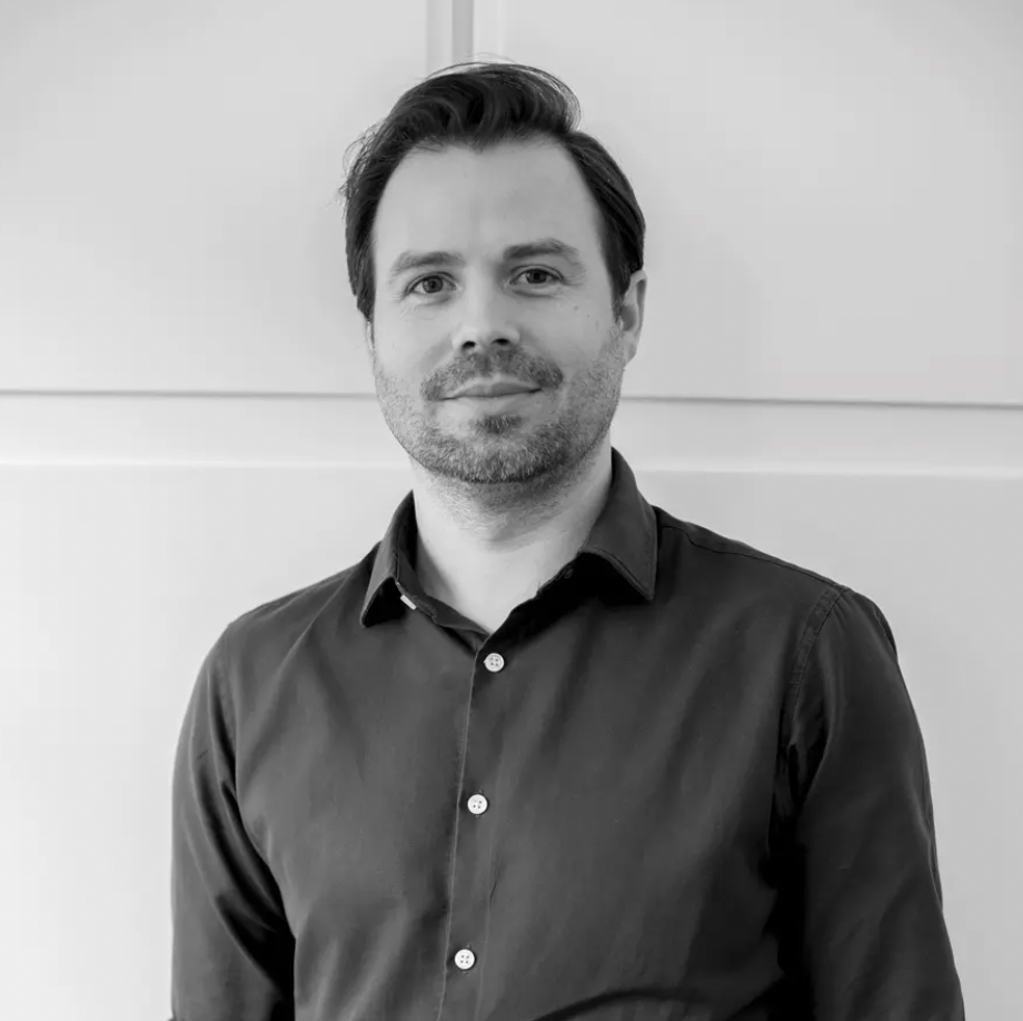 A grayscale headshot of a man with brown hair