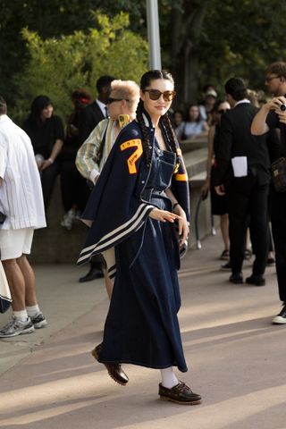 a woman at paris fashion week wearing Sperry boat shoes with charms