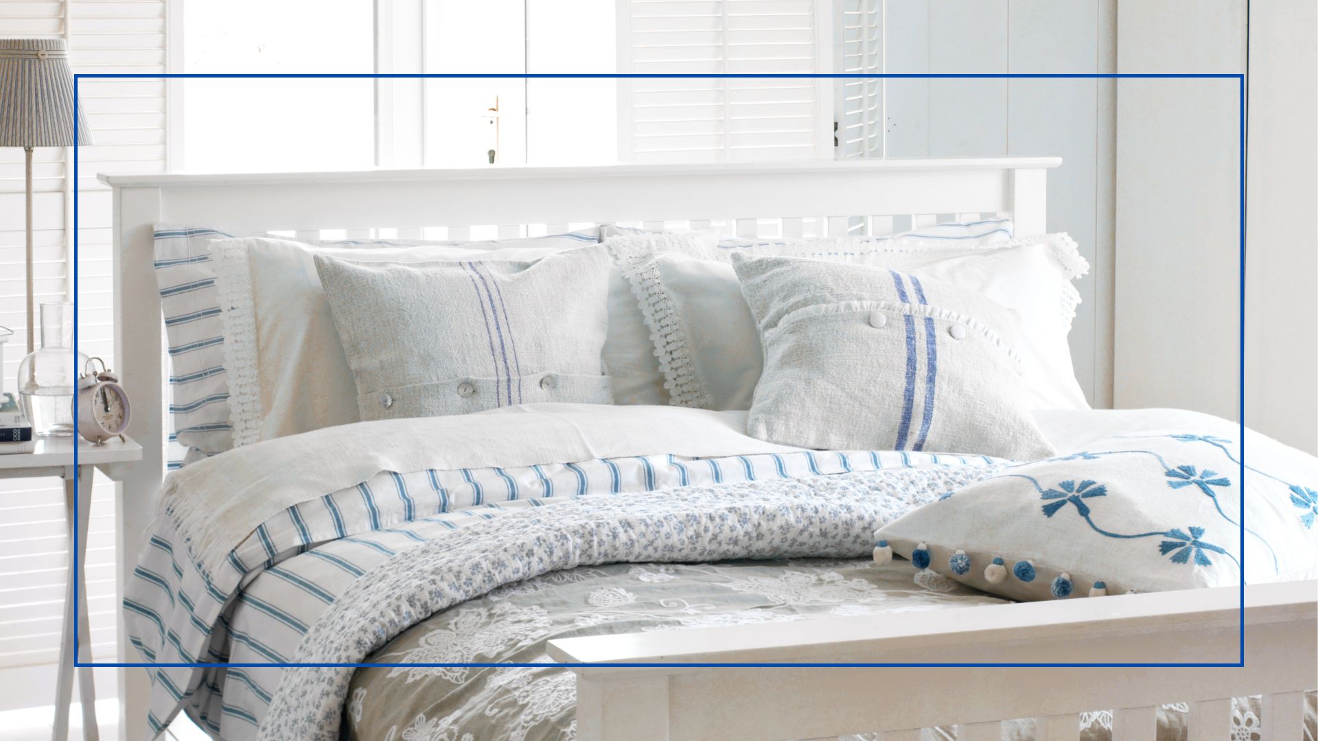 white bedroom with windows open to show show how to keep a bed cool by creating a cross-breeze