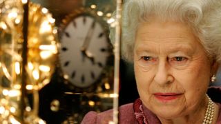 Queen Elizabeth II looking at a clock