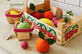 Children's toy fruit in a wooden crate.
