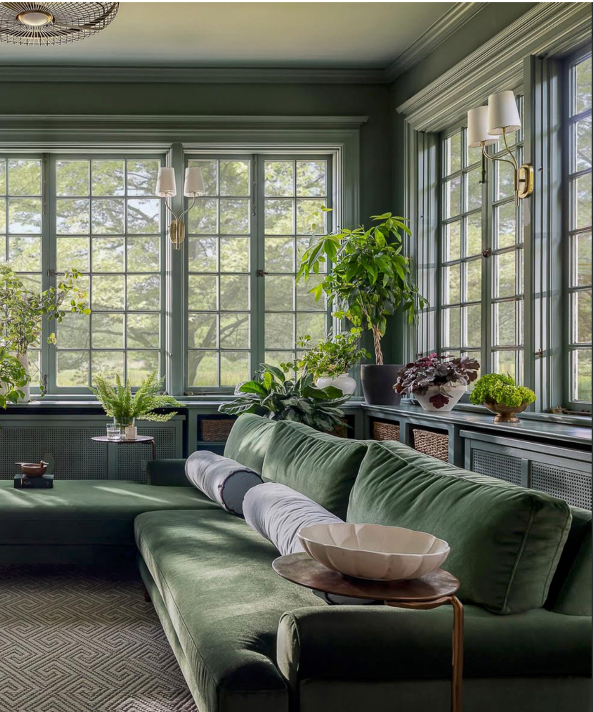Green velvet sofa in light filled room