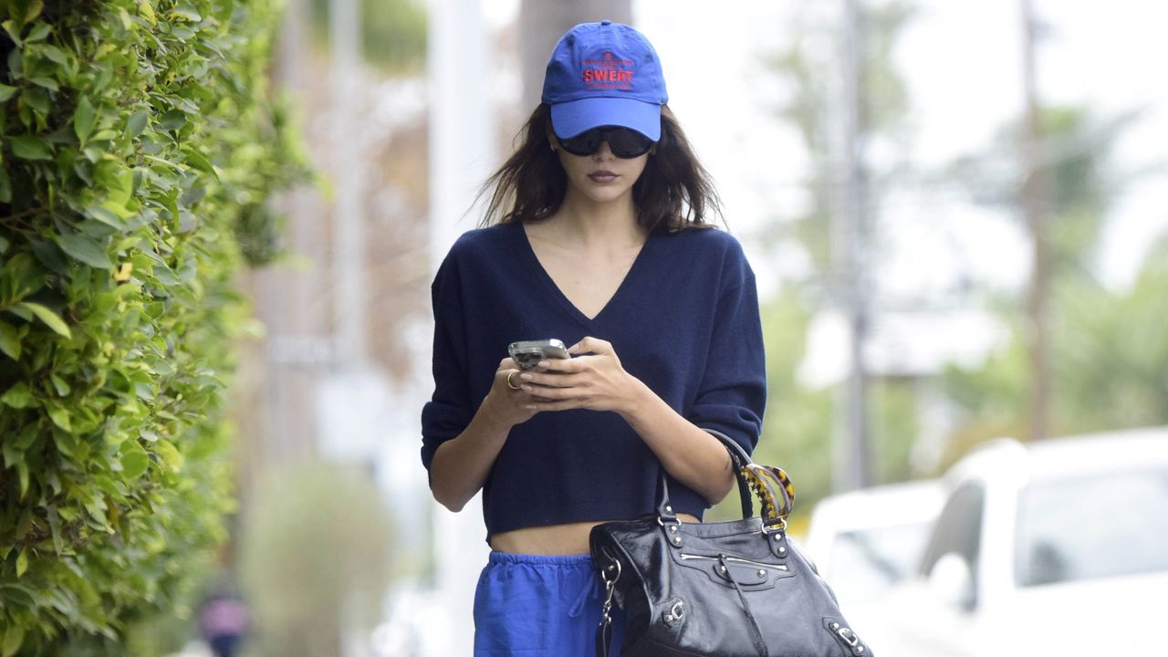 Kaia Gerber wearing a jcrew sweater and carrying a balenciaga bag