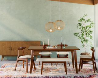 Dark wooden dining table, matching chairs and bench, blue painted walls, rug, sideboard, pendants above table