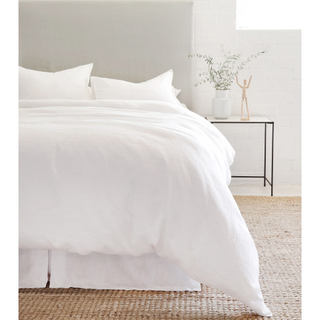 white linen bedding set on a bed