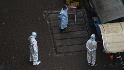 Health officials wearing PPE in streets of Shanghai