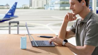 Anker power bank being used to charge a laptop at an airport