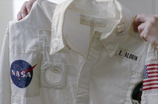 Sotheby's department head Cassandra Hatton holds up the inflight coveralls jacket that Buzz Aldrin wore on the Apollo 11 mission and is now for sale through the New York auction house.