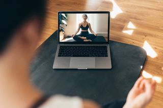 Benefits of yoga: Young Woman Practising Yoga And Meditation With A Video Lesson On Laptop.