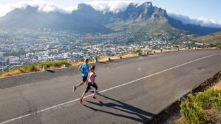 Two road runners in front of a spectacular view of mountains