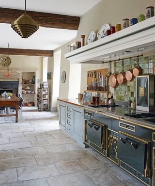 Traditional open plan kitchen with rustic stone flooring and a vintage range oven.