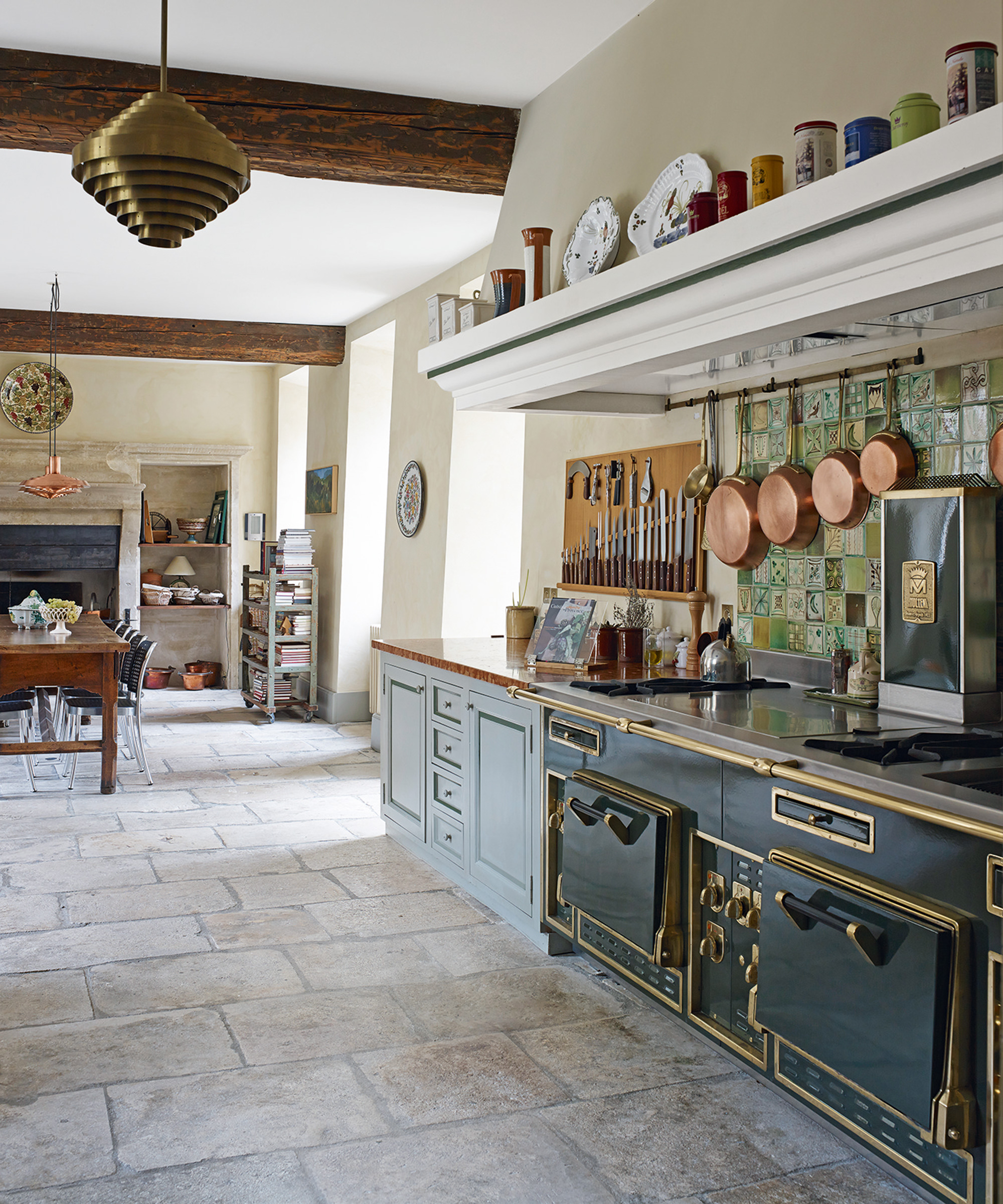 Traditional open plan kitchen ideas with rustic stone flooring and a vintage range oven.