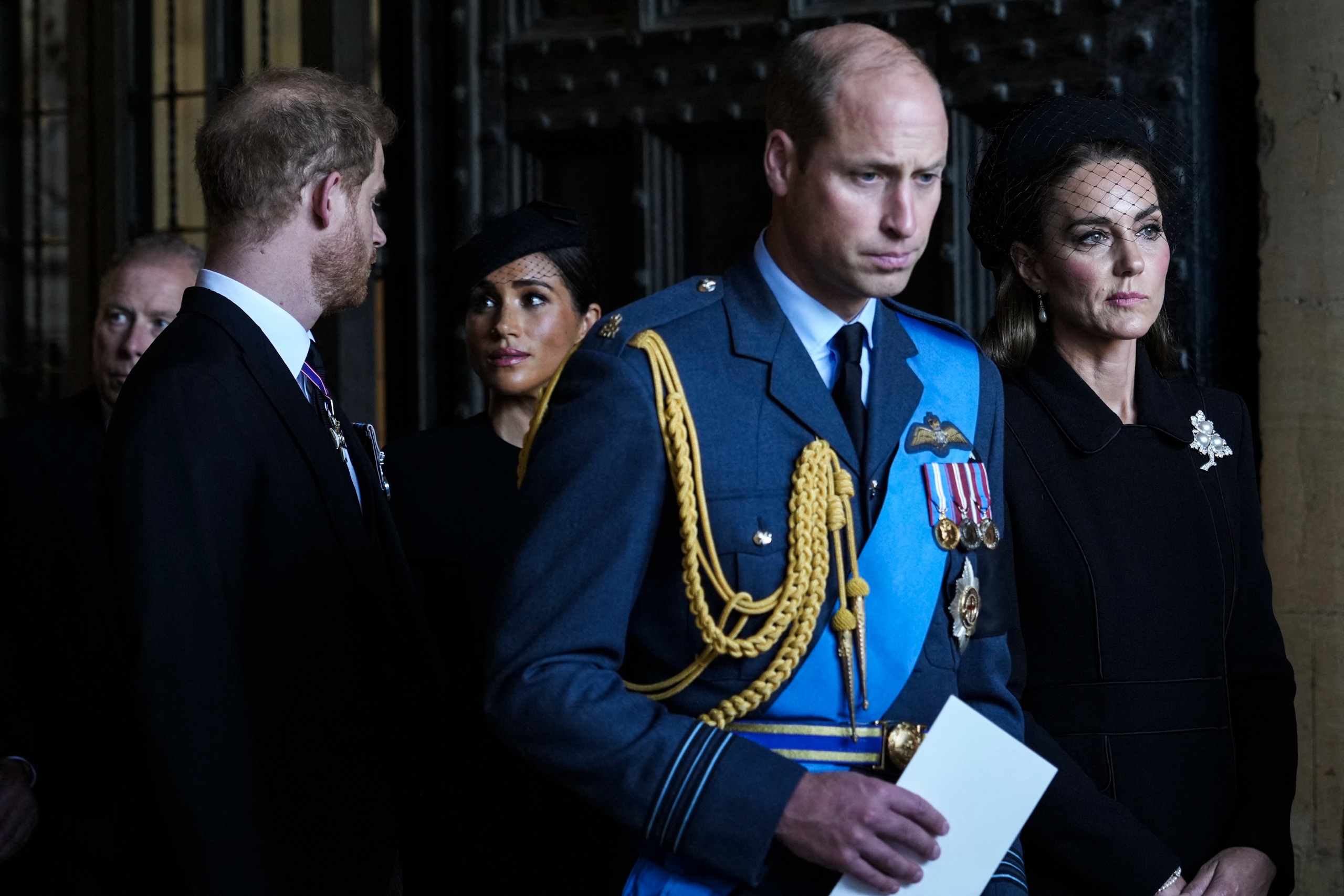 Prince Harry and Meghan Markle standing behind Prince William and Princess Kate at Queen Elizabeth's funeral