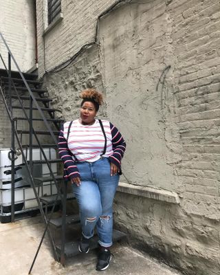 Woman wearing a striped t-shirt and skinny jeans.