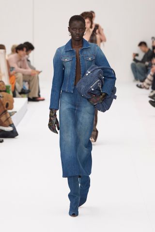 woman wearing a denim jacket and jeans on the Acne Studios Spring 2025 runway