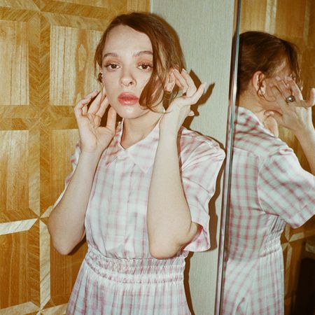 Shira Haas poses next to a mirror at the London Hotel in West Hollywood wearing a pink and white gingham shirtdress. 