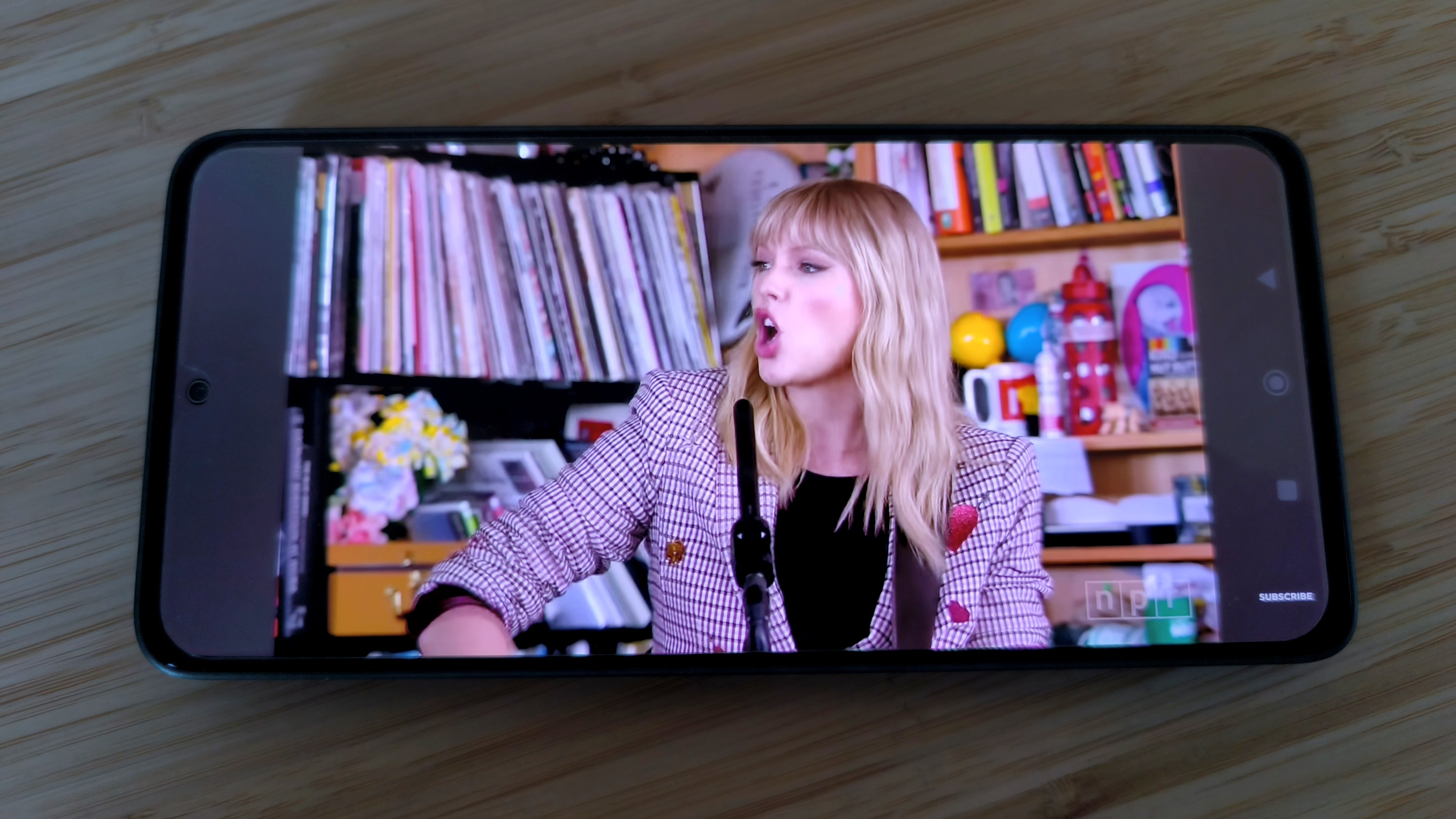 Poco M7 Pro on desk showing Taylor Swift video