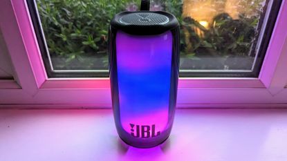 JBL Pulse 5 review: woman holding light up speaker 