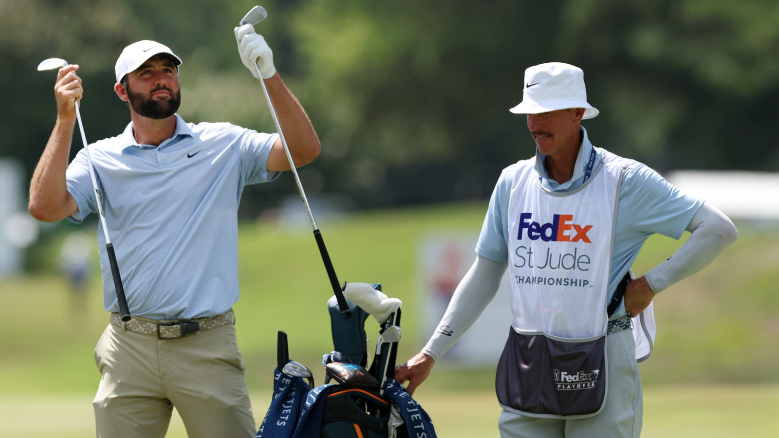 Scottie Scheffler pulls out two clubs from his bag