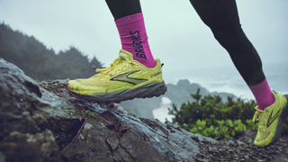 Trail runner's feet on coastal trail wearing the Brooks Cascadia 19 shoes