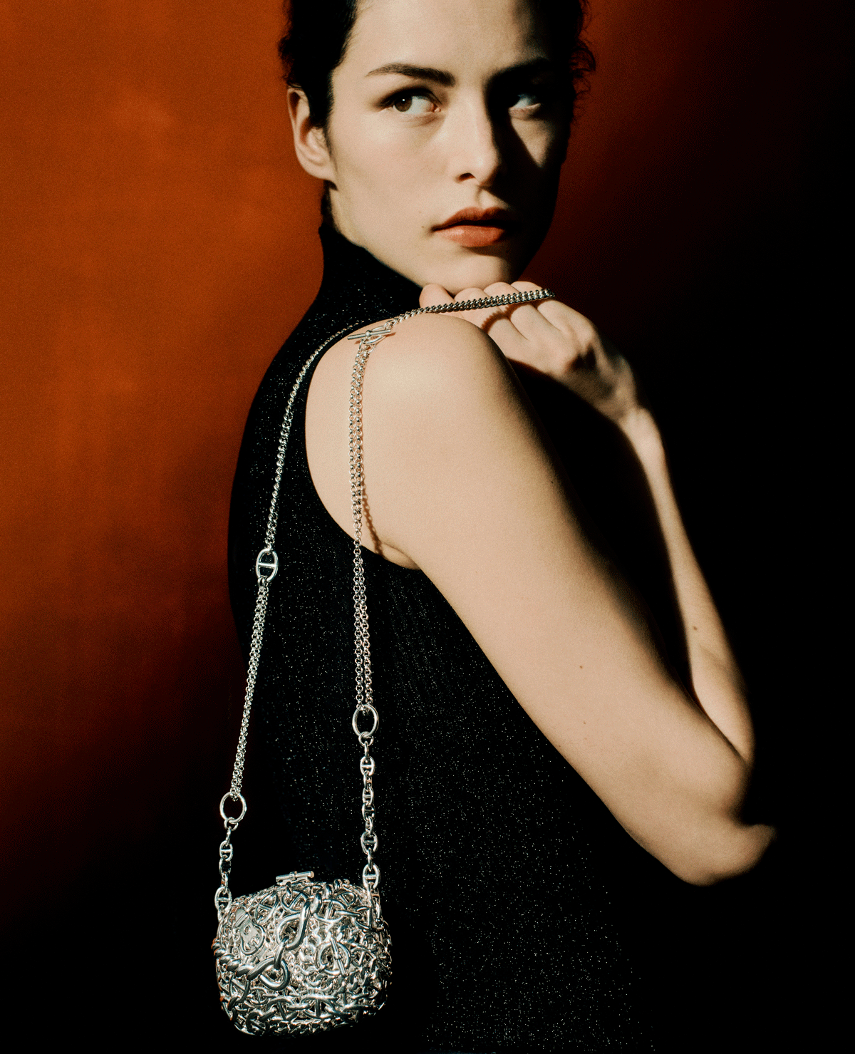 person with silver chain bag over shoulder