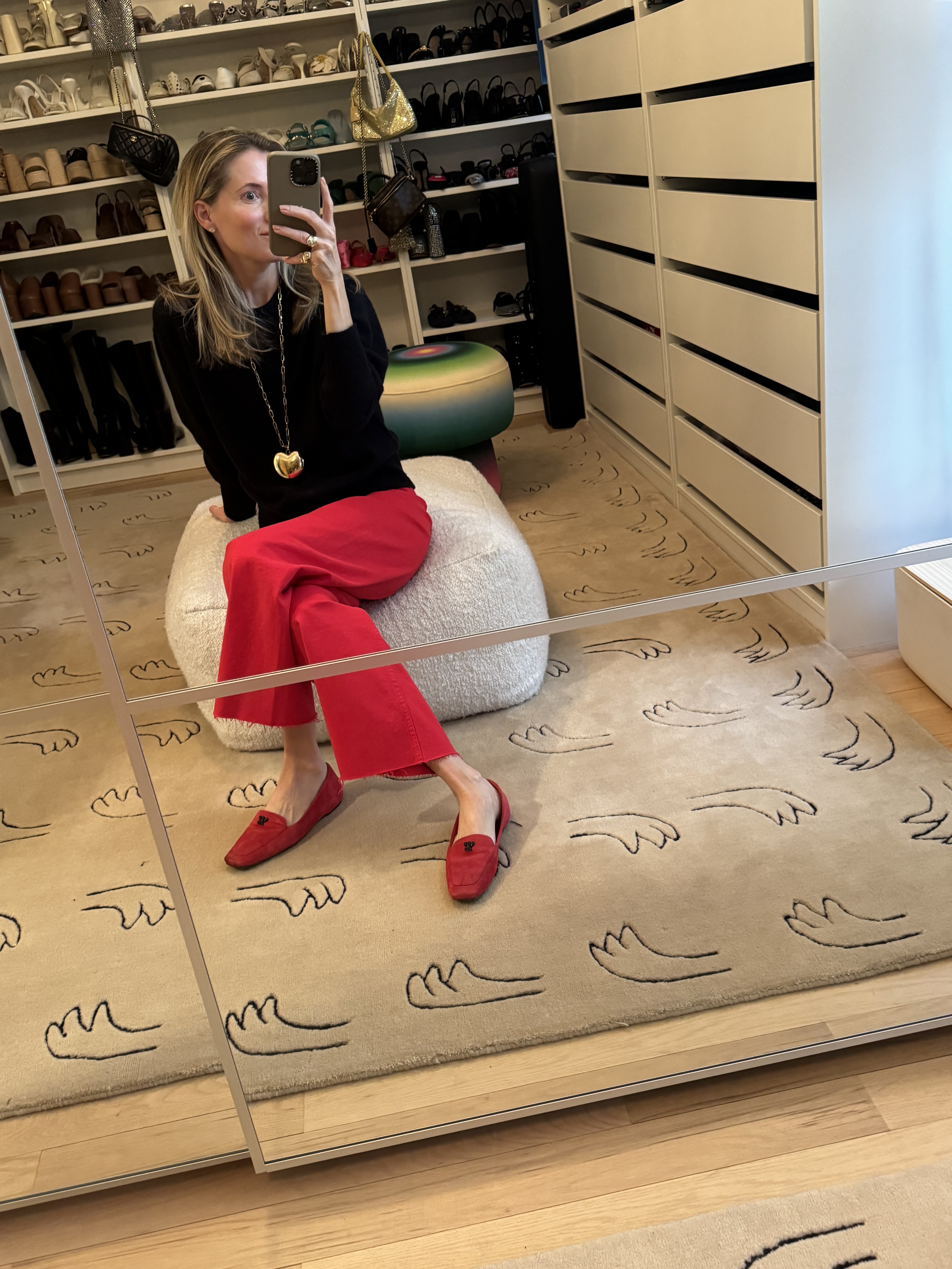 Marina Larroud&amp;eacute; wearing red jeans and a black cashmere crewneck sweater