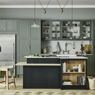 green and wood kitchen with white worktops and wooden floors