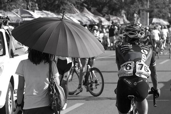 Chang Wei Yi (Giant Asia Racing Team) is escorted from the finish by a tour chauffeur protected from the heat.