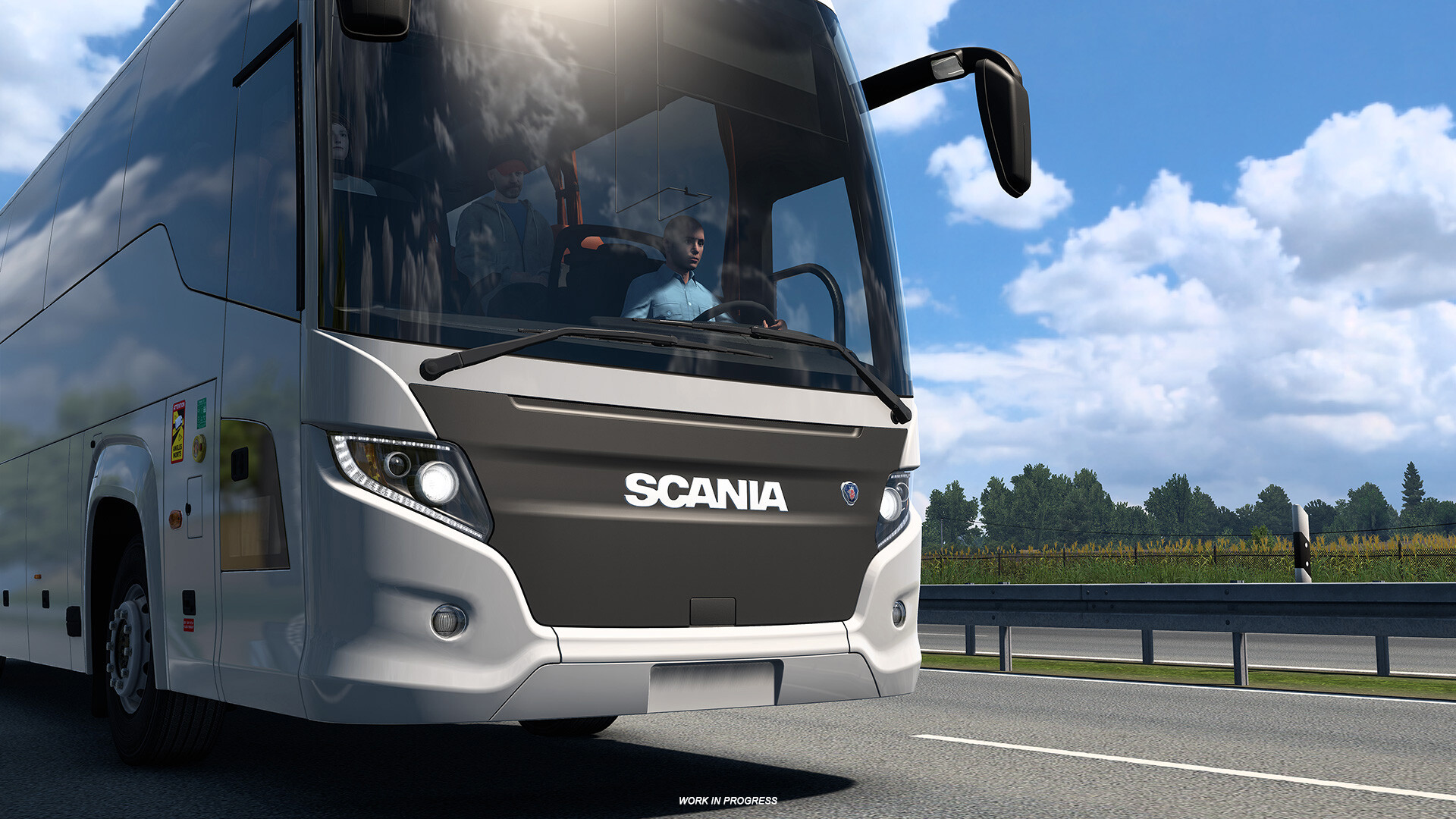 A large white Scania coach drives along a sunny highway in Euro Truck Simulator 2. A small “Work in Progress” label appears at the bottom of the screen.