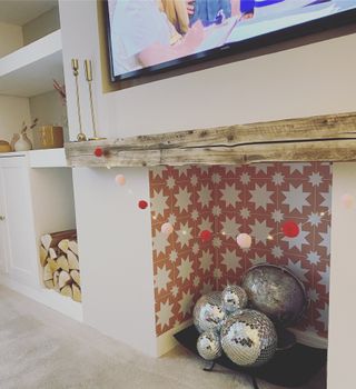 fireplace with pink pattered tiles in a white living room with disco balls